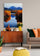 Canvas wall art hung above a mid-century wooden sideboard in a cozy living room, styled with books, a bright yellow vase, decorative pots, and a gray sofa with colorful throw pillows