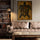 Canvas featuring a turtle with tribal motifs on the wall of an elegant living room with a brown leather sofa and built-in bookcase; warm, refined, cozy