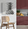 Modern kitchen with textured white wall, wooden bar stool, burgundy and gray kitchen cabinets, fruit