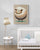Framed poster with a white wood frame hanging above a baby crib, nursery room decor