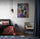 Modern master bedroom with king bed, red and black bedding, statement area rug, black metal armchair, pendant light, white wall, large navy blue curtains, Marilyn Monroe poster
