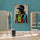 Contemporary poster wall art: black-and-white woman with large round glasses, colorful geometric shapes on a turquoise wall; boho chic decor with rattan and light wood