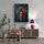Frida Kahlo painting hanging above a boho wood and rattan sideboard with a rattan chair, beige throw, and pink lamp - warm natural wall decor