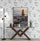 Affiche zen avec pierres empilées exposée sur un mur à motifs floraux, posée sur une console moderne en bois foncé.