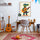 Cozy kids' room with a wooden desk, playful decor, and wall art of a colorful crocodile playing guitar; soft, creative vibe with retro touches