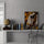 Modern minimalist shelf styled with books, a globe, and a horse head wall art leaning against a gray wall