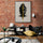 Stylized Buddha poster in a brick-wall interior with a modern bookshelf; black-and-yellow artwork creates strong visual contrast