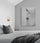Modern primary bedroom with king‑size bed in gray and black, wall sconce, nightstand, decor accents, framed photo wall art