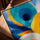Tableau abstrait cercles concentriques bleu turquoise orange jaune texture épaisse présenté avec cadre chêne doré