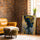 Tableau africain femme de profil aux motifs tribaux bleu doré dans salon mur brique fauteuil cuir camel