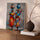 African painting of women carrying jars, colorful turbans, modern living room decor above sideboard