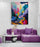 Modern living room with a purple sofa, round coffee table, and a colorful abstract landscape wall art contrasting with minimalist furniture