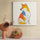 Framed Shiba Inu illustration displayed beside a floral arrangement