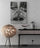 Scandinavian interior with black and pink dresser, floor lamp and white wall showcasing a giraffe poster