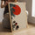 Modern zen wall art with red sun, pine branches and tea bowls in natural wood frame for living room
