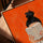 Tableau moderne femme lisant fond orange vif sur table avec cadre chêne doré décoration salon