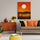 Retro living room wall decor featuring a sunset painting, vintage wood furniture, and orange and green cushions
