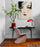 Minimalist home office decor with geisha wall art, flowering plant, and a red lamp
