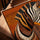 Zebra art with African tribal motifs in orange and brown, framed in golden oak and displayed in a living room