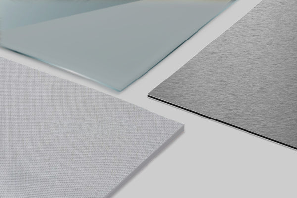 La comparaison de trois tableaux vierges aux matières différentes. L'un en en toile, un autre en plexiglas et le dernier en aluminium