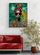 Colorful African woman canvas adds a vibrant accent above a modern red sofa in a minimalist living room