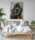 Master bedroom with double bed, rattan accents, white bedding, wooden nightstand, large green plant, abstract couple print on the wall