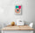 Petit cadre toile, sur le mur d'une cuisine d'un donut dessiné à la main. Crème de couleur rose et est parsemée de pépites multicolores. L'arrière-plan du tableau est composé de deux traces de peinture, un beau rouge et l'autre verte, qui ajoutent de la profondeur et de la dimension à l'ensemble. Le tableau est très esthétique et aux couleurs vives. Minimaliste, ce tableau dégage une touche de fraîcheur et de féminité combinée au donut qui ajoute vie et gourmandise