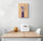 Small kitchen wall decor hanging above a table and two white chairs