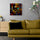 Small Arabic cityscape framed wall art on a living room wall, warm-toned houses with intricate mosaics, stained-glass inspired, narrow Middle Eastern alleys and rising minarets