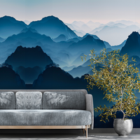 canapé gris ossature en bois, plante olivier dans un pot argente tapisserie panoramique paysage montagne