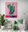 living room area, comfy chair, green cushion and throw, side table, large green plant, light gray wall, pendant lighting, pink cactus canvas