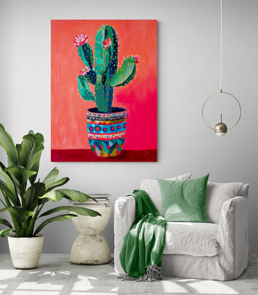 pièce de vie, fauteuil confortable, coussin et plaid vert, table d'appoint, grande plante verte, mur gris clair, lumière en suspension, tableau cactus rouge.