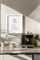 Affiche murale minimaliste sur le café en plusieurs langues, encadrée en blanc et accrochée dans une cuisine moderne avec machine à expresso.