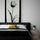 Modern bedroom with a large black and white tulip canvas above the bed, neutral decor and a yellow accent pillow