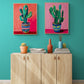 Deux tableaux colorés de cactus sont accrochés au-dessus d'un buffet moderne en bois clair, apportant une touche artistique vivante à un salon aux murs turquoise