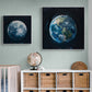 chambre d'enfant avec deux tableaux de la Terre et de la Lune accrochés au mur au-dessus d'un meuble de rangement.