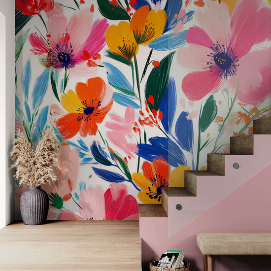 Un escalier contemporain sublimé par un mur tapissé d’un motif floral coloré. Les teintes vibrantes du papier peint contrastent avec les marches en bois naturel et les touches de rose, apportant une ambiance chaleureuse et chic.