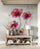 Une entrée décorée avec des vases et une lampe, parfaitement harmonisée avec le fond mural fleuri.