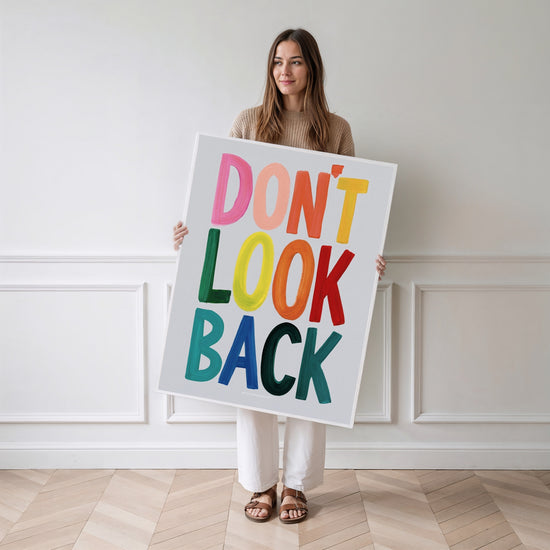 Woman standing with "Don't Look Back" poster