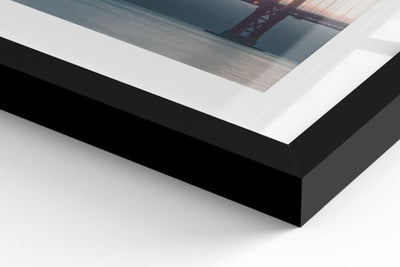 Close-up of a framed poster with a sleek black frame, highlighting an artistic photograph. The glossy glass and sharp edges add a modern and elegant touch. Ideal for refined wall decor.