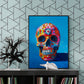 Poster de crâne coloré sur meuble noir, fond géométrique gris.