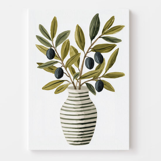 Print featuring a striped vase adorned with olive branches, showcased in a kitchen decorated with modern and natural elements (plants, metal carafe, fruits). The overall feel is fresh and authentic.
