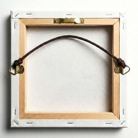 Vue arrière d’un tableau sur toile avec un système de suspension par corde tendue, fixée à deux crochets métalliques sur les bords du châssis en bois. L’ensemble est prêt à être accroché au mur.