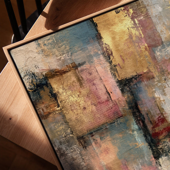Textured modern abstract canvas in gold, pink and blue, styled above a sofa and coffee table