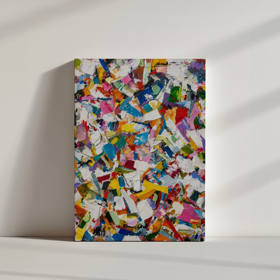 Abstraktes, mehrfarbiges Gemälde mit dynamischen Pinselstrichen, am Boden vor weißer Wand – minimalistische Szene