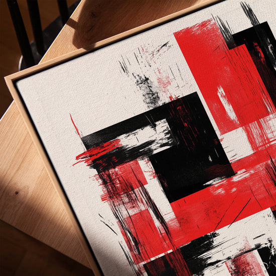 Canvas texture of a red and black abstract painting with a light oak frame