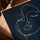 Abstract one‑line female face in white on navy blue, framed wall art in warm oak tone