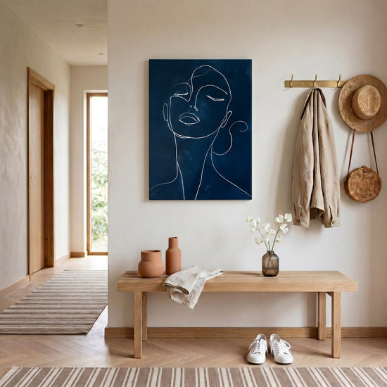 Modern minimalist line art of a woman’s face, white continuous line on dark blue, gallery‑style decor