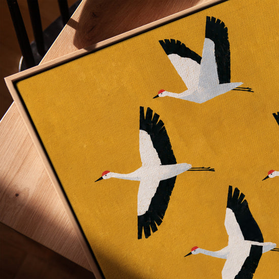Tableau animaux grues blanches en vol sur fond jaune moutarde style minimaliste pour salon moderne