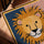 Lion wall art in oak-gold frame — nursery decor with mustard-yellow lion on blue and pink